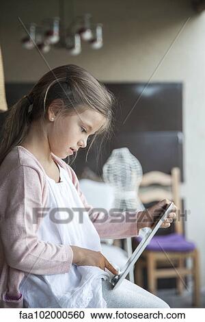 Stock Image - Little girl using digital tablet. Fotosearch