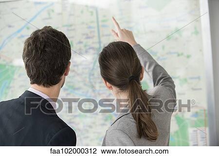 Stock Image - Man and woman looking at Paris metro map together. Fotosearch