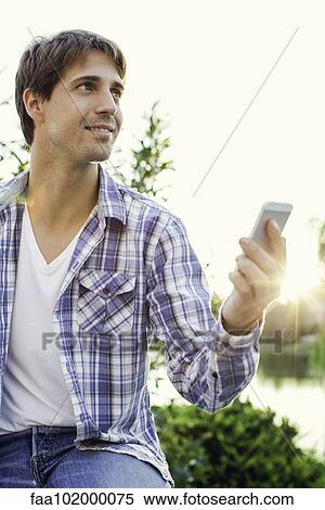 Man sending inspired tweet while enjoying being outdoors View Large Photo Image Stock Photography - Man sending inspired tweet while enjoying being outdoors. Fotosearch