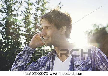 Man taking phone call on cell phone while enjoying being outdoors View Large Photo Image Stock Image - Man taking phone call on cell phone while enjoying being outdoors. Fotosearch