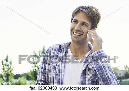 Man taking phone call on cell phone while enjoying being outdoors View Large Photo Image Stock Photo - Man taking phone call on cell phone while enjoying being outdoors. Fotosearch