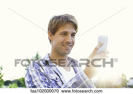 Man text messaging while enjoying outdoors View Large Photo Image Stock Image - Man text messaging while enjoying outdoors. Fotosearch