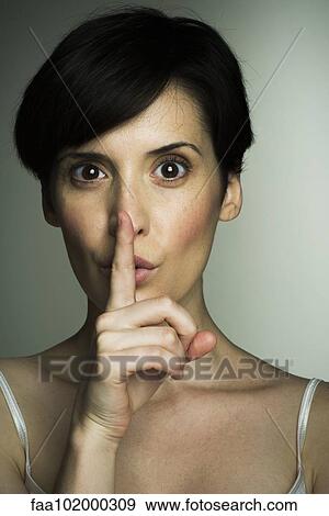 Mid-adult woman making shush gesture View Large Photo Image Stock Photo - Mid-adult woman making shush gesture. Fotosearch