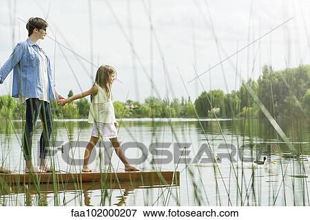 Mother and daughter holding hands on dock View Large Photo Image Stock Photo - Mother and daughter holding hands on dock. Fotosearch