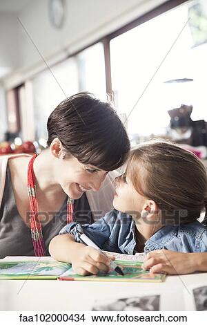 "Mother and young daughter reading together, affectionately touching foreheads" View Large Photo Image Picture - "Mother and young daughter reading together, affectionately touching foreheads". Fotosearch
