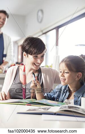Stock Photography - Mother and young daughter reading together. Fotosearch