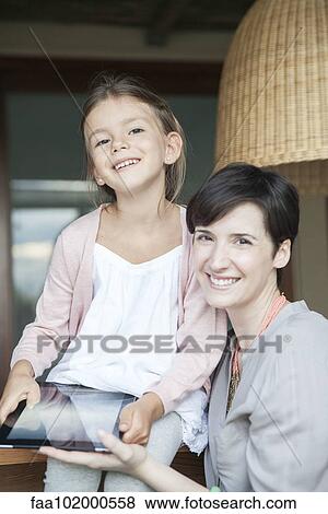 Stock Photo - Mother and young daughter using digital tablet together. Fotosearch