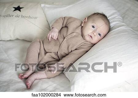 Picture - "Newborn baby lying on pillow, portrait". Fotosearch