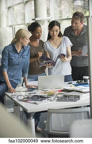Office workers collaborating on project View Large Photo Image Stock Photo - Office workers collaborating on project. Fotosearch