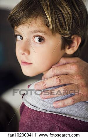 Stock Image - "Parent's hand on boy's shoulder, cropped". Fotosearch