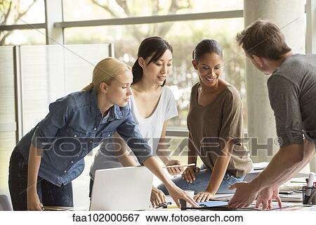 Project team working closely on assignment View Large Photo Image Stock Photo - Project team working closely on assignment. Fotosearch