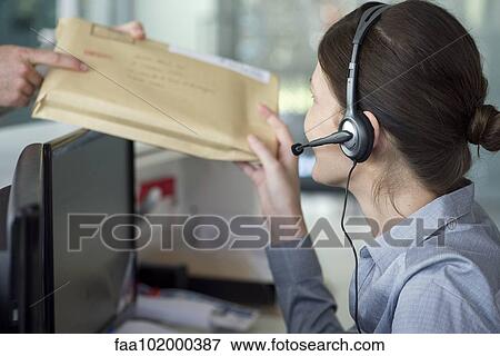 Receptionist receiving mail from delivery person View Large Photo Image Stock Photo - Receptionist receiving mail from delivery person. Fotosearch