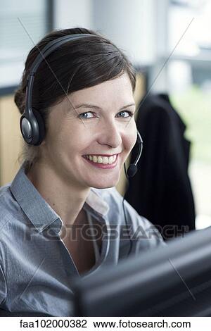 Stock Image - "Receptionist smiling cheerfully, portrait". Fotosearch
