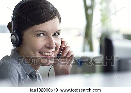 Receptionist smiling cheerfully View Large Photo Image Stock Photo - Receptionist smiling cheerfully. Fotosearch