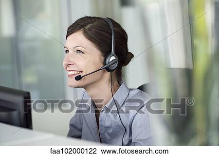 "Receptionist wearing headset, smiling cheerfully" View Large Photo Image Stock Image - "Receptionist wearing headset, smiling cheerfully". Fotosearch