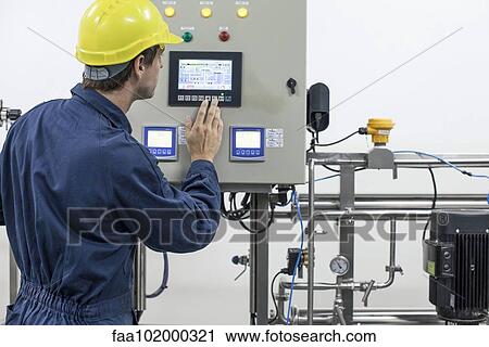 Skilled worker operating industrial equipment View Large Photo Image Stock Image - Skilled worker operating industrial equipment. Fotosearch