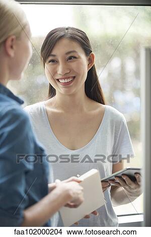Picture - "Woman chatting with friend, smiling". Fotosearch