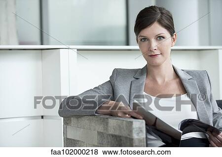 Woman in waiting room looking at magazine View Large Photo Image Stock Photo - Woman in waiting room looking at magazine. Fotosearch