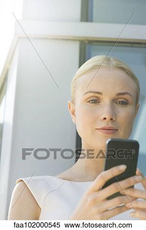Woman looking at smartphone View Large Photo Image Stock Photography - Woman looking at smartphone. Fotosearch