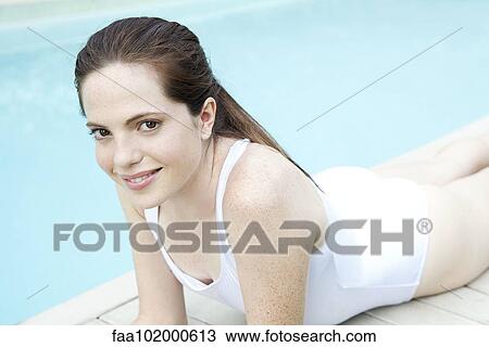 "Woman sunbathing by pool, portrait" View Large Photo Image Stock Image - "Woman sunbathing by pool, portrait". Fotosearch