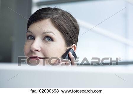 Woman using cell phone in office View Large Photo Image Stock Photo - Woman using cell phone in office. Fotosearch