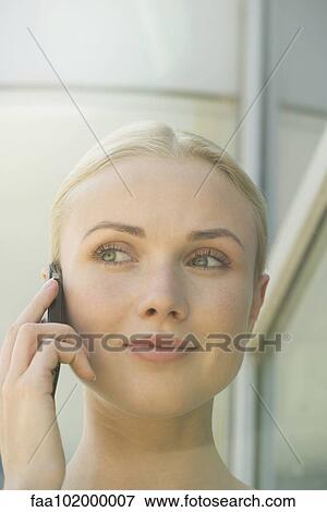 Stock Photo - "Woman using cell phone, smiling". Fotosearch