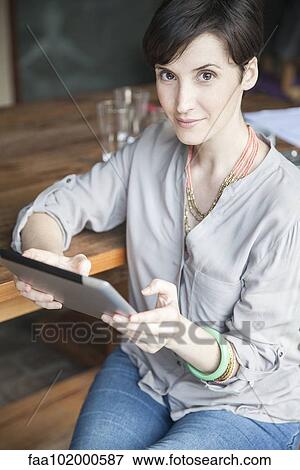 Stock Photo - "Woman using digital tablet, portrait". Fotosearch
