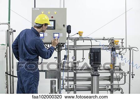 Worker operating industrial equipment View Large Photo Image Stock Image - Worker operating industrial equipment. Fotosearch