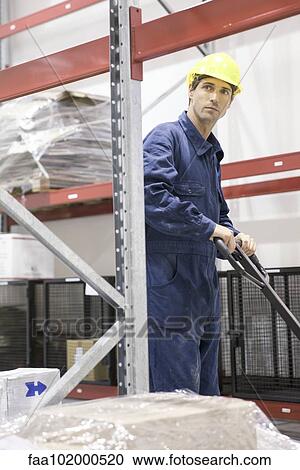 Worker operating pallet jack in warehouse View Large Photo Image Stock Image - Worker operating pallet jack in warehouse. Fotosearch