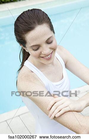 Young woman applying sunscreen View Large Photo Image Stock Photo - Young woman applying sunscreen. Fotosearch