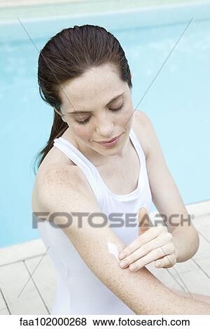 Young woman applying sunscreen View Large Photo Image Stock Photo - Young woman applying sunscreen. Fotosearch