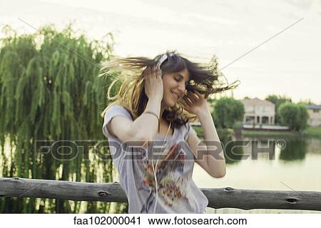 Young woman enthusiatically listening to music View Large Photo Image Stock Image - Young woman enthusiatically listening to music. Fotosearch