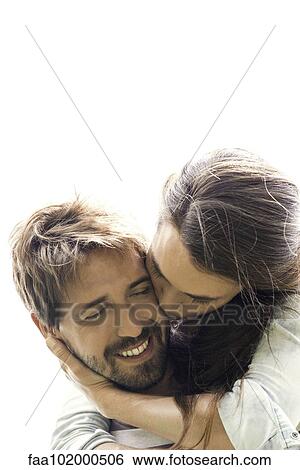 Stock Photograph - Young woman kissing boyfriend. Fotosearch