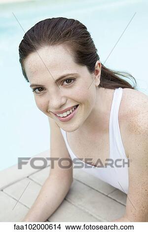 Picture - "Young woman sunbathing by pool, smiling, portrait". Fotosearch