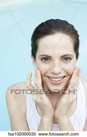 "Young woman touching her cheeks, smiling cheerfully, portrait" View Large Photo Image Stock Photography - "Young woman touching her cheeks, smiling cheerfully, portrait". Fotosearch