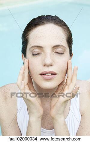 "Young woman touching her face, eyes closed" View Large Photo Image Picture - "Young woman touching her face, eyes closed". Fotosearch