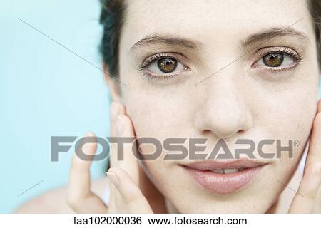 "Young woman touching her face, close-up portrait" View Large Photo Image Stock Photograph - "Young woman touching her face, close-up portrait". Fotosearch