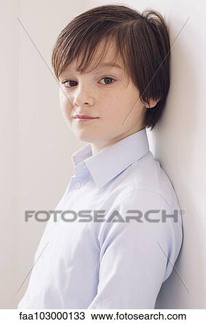 Stock Image - "Boy leaning against wall, portrait". Fotosearch