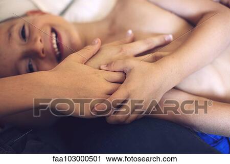 "Boy lying on back, holding family members' hands" View Large Photo Image Stock Image - "Boy lying on back, holding family members' hands". Fotosearch