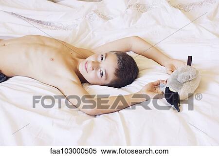 "Boy lying on bed with stuffed penguin, portrait" View Large Photo Image Stock Photography - "Boy lying on bed with stuffed penguin, portrait". Fotosearch