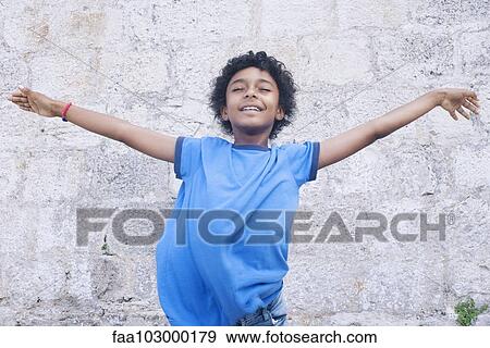 "Boy standing with his arms outstretched, eyes closed, portrait" View Large Photo Image Stock Photo - "Boy standing with his arms outstretched, eyes closed, portrait". Fotosearch