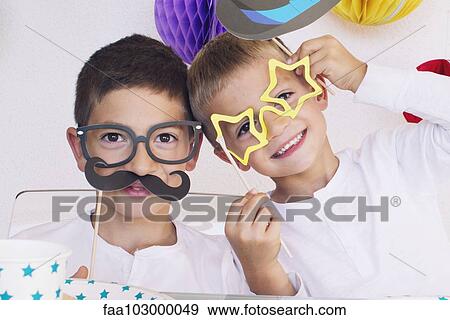 Stock Photo - Boys wearing funny disguises at birthday party. Fotosearch