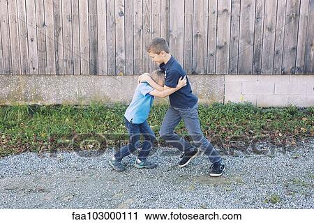 Brothers rough housing outdoors View Large Photo Image Stock Image - Brothers rough housing outdoors. Fotosearch