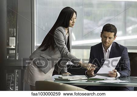 Business associates collaborating on document View Large Photo Image Stock Photo - Business associates collaborating on document. Fotosearch