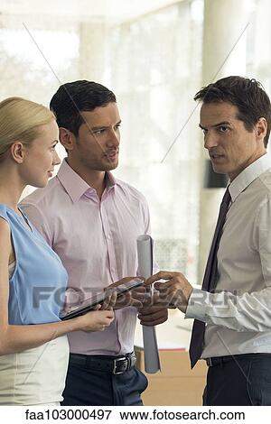 Business associates conversing View Large Photo Image Stock Photo - Business associates conversing. Fotosearch