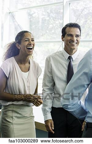 Stock Photo - Business associates having lighthearted moment together in office. Fotosearch
