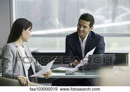 Stock Photo - Business associates reviewing document. Fotosearch