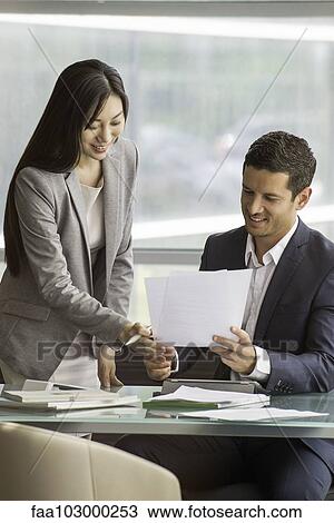 Business professionals reviewing agreement together View Large Photo Image Stock Image - Business professionals reviewing agreement together. Fotosearch