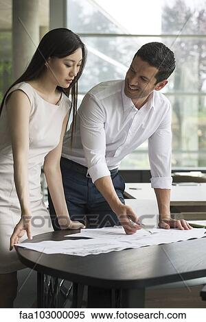 Stock Photography - Business professionals working together on project. Fotosearch