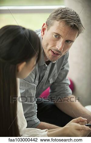 Stock Image - Businessman talking with female colleague. Fotosearch